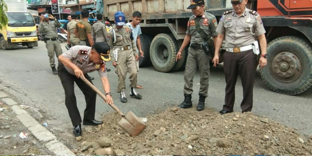 Jalan di Depan Pajak Lama Berlubang, Kapolsek dan Kanit Lantas Lakukan Antisipasi Dengan Melakukan Penimbunan 