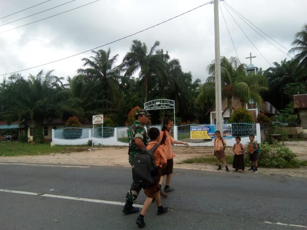 Arus Lalin Cukup Padat dan Rawan, Babinsa Seberangkan Anak Sekolah 