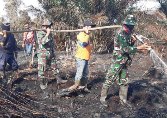 Danramil 05/Rupat Beserta Jajaran lain Lakukan Pendinginan di Bekas Lahan yang Terbakar