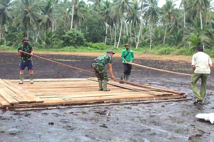 Satgas TMMD ke-111 Kodim 0314/lnhil Gotong Royong Melansir Papan Kayu di Desa Teluk Bunian