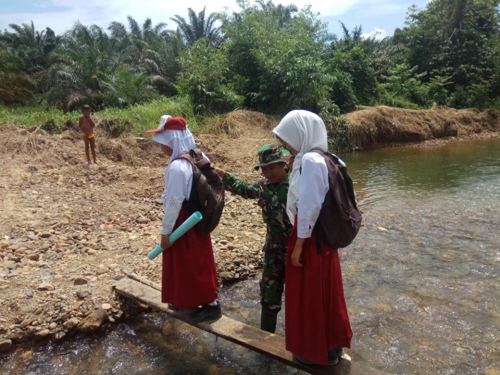 SATGAS TMMD KE 105 KODIM 0313/KPR BANTU SEBERANGI ANAK SEKOLAH