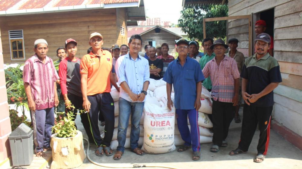 Kades Pangkalan Nyirih  menyerahkan bantuan pupuk Urea dan MPK kepada masyarakat kelompok tani Padi.