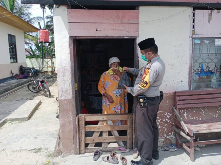 Bhabinkamtibmas Polres Kuansing keliling kampung berbagi Daging Kurban