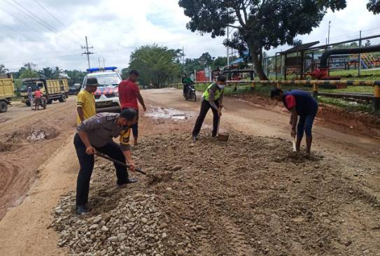 Tak Kunjung Diperbaiki, Anggota Polsek Tapung Hulu Dibantu Warga Timbun Jalan yang Rusak Parah